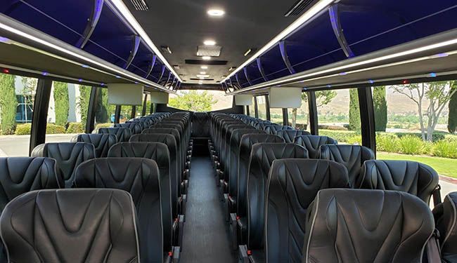 Interior of a charter bus with leather seats and storage